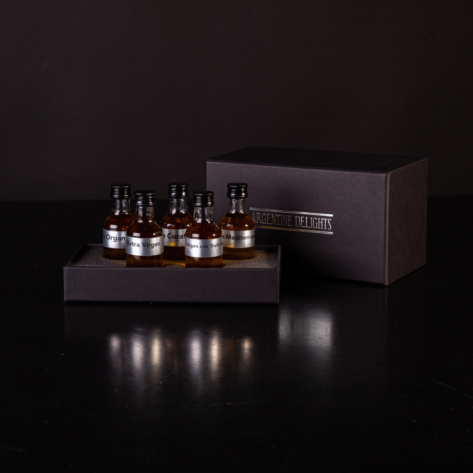 Argentine Delights · Selección exclusiva en presentación de lujo · Cinco monodosis premium sobre caja negra con branding institucional